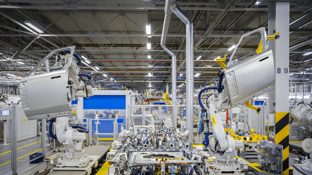 Robotic arms applying induction bonding to car doors in a modern automotive factory using ENRX technology