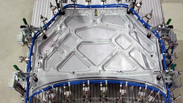 Automotive body panel in an ENRX induction bonding fixture for structural adhesive curing