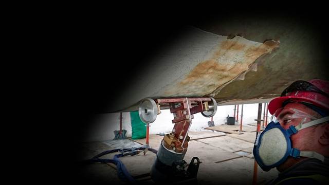 Induction heating used to remove protective coating from ship hull steel during maintenance