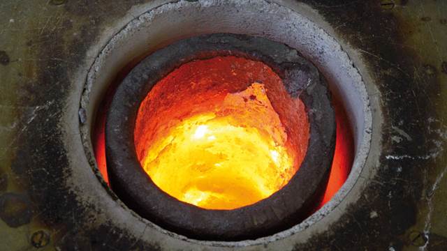 Close-up view inside an induction furnace crucible showing molten metal during controlled high-temperature melting.