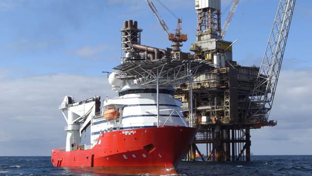 Offshore support vessel positioned beside an oil and gas platform
