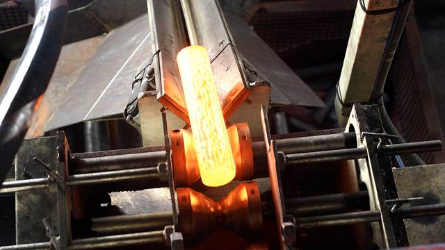 Hot steel billet heated in an industrial induction forging system using precision induction heating
