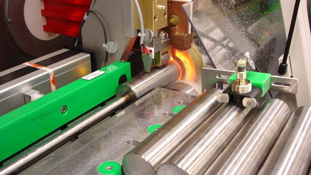 ENRX induction heat treatment system hardening a steel shaft in an automated inline setup