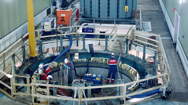 Technicians using an ENRX Minac Twin for induction brazing of generator windings inside a power equipment facility.