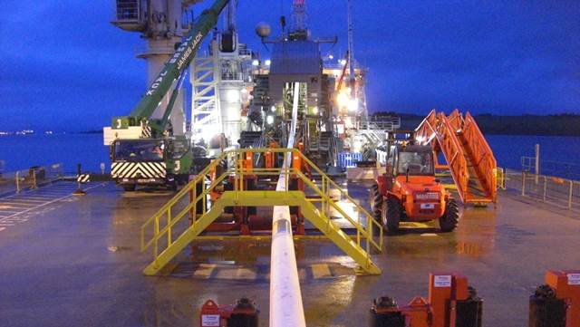 Subsea pipe‑laying operation on a vessel deck during offshore installation