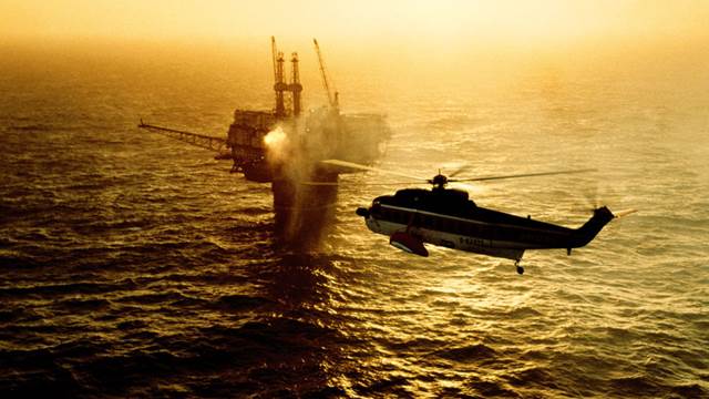 Helicopter approaching offshore oil platform where ENRX induction heating supports maintenance and repair operations