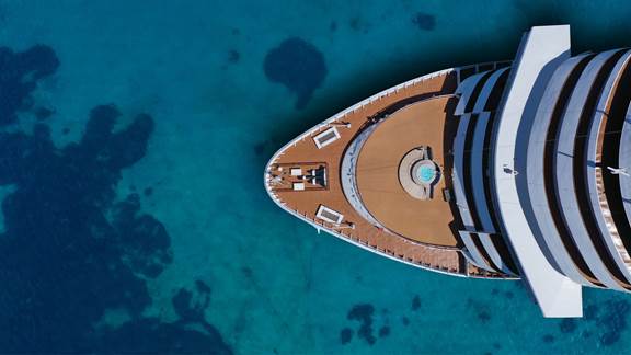 Aerial view of a cruise ship’s bow in clear blue water where ENRX induction heating is used in shipbuilding and structural maintenance