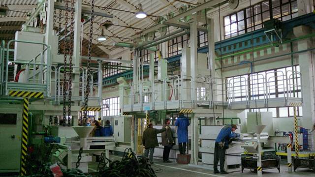 Industrial workshop with a two-line ENRX chain heat treatment system, featuring induction heating equipment and multiple workstations for hardening processes