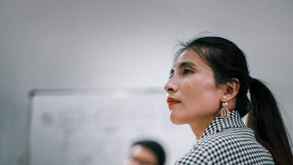 Business professional listening attentively in a meeting with colleagues, representing ENRX news and press releases about induction heating