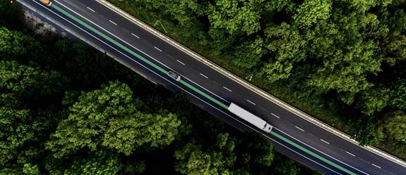 Aerial view of ENRX Dynamic Roadway with green inductive charging lane through forested highway