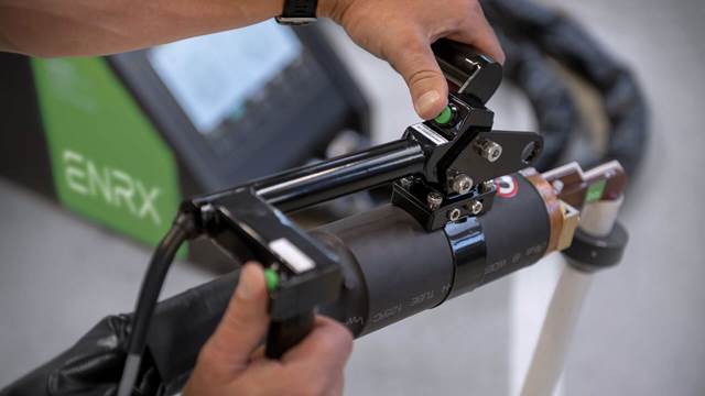 Technician using ENRX handheld induction bolt‑heating tool for controlled bolt expansion