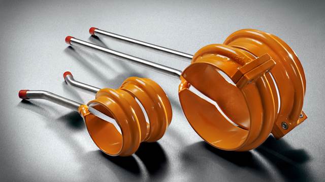Two ENRX induction coils of different sizes in orange with stainless steel connectors, used in high-frequency induction welding of tubes and pipes