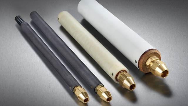 Four ENRX through flow impeders of different sizes and materials — grey ferrite and white ceramic — with brass water fittings, used in high-frequency tube and pipe welding