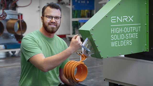 ENRX Person wechselt Spule an Weldac-Rohrschweißanlage