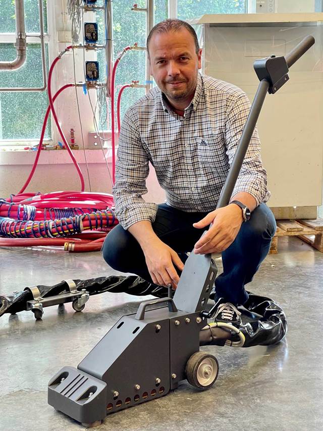 ENRX technician demonstrating portable induction straightening equipment used for precise heat-based alignment of metal structures.