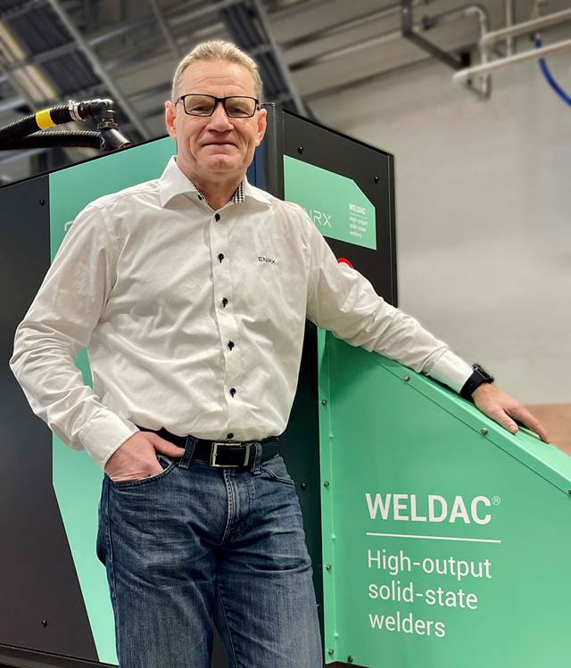 ENRX Morten Lavergren standing next to a WELDAC high-output solid-state welder inside an industrial facility.  