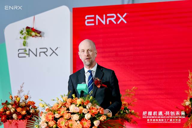 Norwegian ambassador to China, Vebjørn Dysvik speaking at the opening ceremony of the new ENRX factory in China, standing at a decorated podium. 