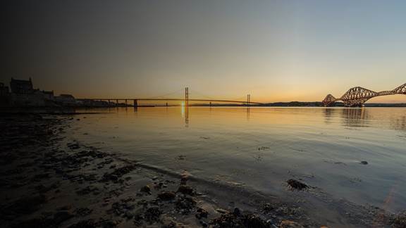 Forth Bridge and Forth Road Bridge at sunset in South Queensferry, Scotland.