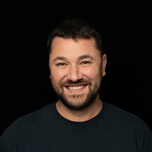 Portrait of Veronus Maria, ENRX team member, photographed against a black background