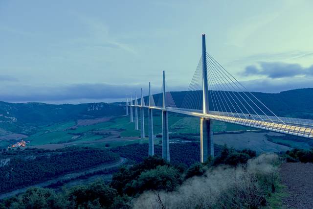 Millau Viaduct at dusk in France, cable-stayed bridge with smart monitoring systems.